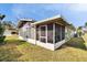 Home exterior showcasing a screened porch and yard at 4188 104Th N Ave, Clearwater, FL 33762