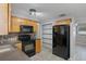 Modern kitchen with wood cabinets, black appliances and tile floors at 4925 Beacon Hill Dr, New Port Richey, FL 34652