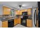 Updated kitchen, featuring wood cabinets and black appliances at 4925 Beacon Hill Dr, New Port Richey, FL 34652