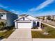 White house with brown accents, a two-car garage, and well-manicured landscaping at 682 Olive Conch St, Ruskin, FL 33570