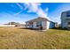House back view, AC unit visible, grassy backyard at 682 Olive Conch St, Ruskin, FL 33570