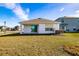 Back of house with covered patio and grassy yard at 682 Olive Conch St, Ruskin, FL 33570