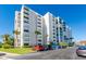 Exterior view of a condominium building with ample parking and lush landscaping at 855 Bayway Blvd # 804, Clearwater Beach, FL 33767
