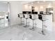 Sleek kitchen island with four barstools and marble countertops at 855 Bayway Blvd # 804, Clearwater Beach, FL 33767