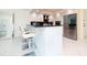 Modern kitchen with breakfast bar, white cabinets and marble floor at 855 Bayway Blvd # 804, Clearwater Beach, FL 33767