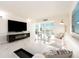 Elegant living room boasts a large TV, white sectional, and marble floors at 855 Bayway Blvd # 804, Clearwater Beach, FL 33767