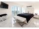 Serene bedroom with white bedding, marble floors, and balcony access at 855 Bayway Blvd # 804, Clearwater Beach, FL 33767