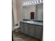 Bathroom boasts vanity with gray cabinets and shower at 1028 Tullamore Dr, Wesley Chapel, FL 33543