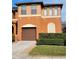 Two-story house with brown garage door and manicured hedges at 1028 Tullamore Dr, Wesley Chapel, FL 33543
