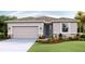 Single-story home with attached garage, landscaping, and neutral color palette at 10818 Patoka Ter, Parrish, FL 34219