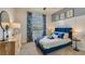 Bright bedroom featuring a blue upholstered bed and stylish decor at 10822 Patoka Ter, Parrish, FL 34219