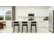 Modern kitchen with white cabinets, island, and stainless steel appliances at 12661 Lily Quartz Loop, Parrish, FL 34219