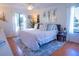 Spacious bedroom with king-size bed, wood floors, and large windows at 1433 Pine Glen Pl # G2, Tarpon Springs, FL 34688