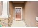Front entry with brown door, stone accents, and a welcome mat at 15571 Stone House Dr, Brooksville, FL 34604