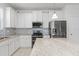 Modern kitchen with white cabinets, granite countertops, and stainless steel appliances at 15571 Stone House Dr, Brooksville, FL 34604
