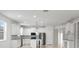 Open concept kitchen with white cabinets, granite island, and stainless steel appliances at 15571 Stone House Dr, Brooksville, FL 34604