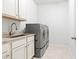Bright laundry room with washer, dryer, and utility sink at 15571 Stone House Dr, Brooksville, FL 34604