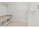 Laundry area with built-in storage, granite countertop and bench at 15571 Stone House Dr, Brooksville, FL 34604