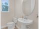 Small bathroom with pedestal sink and toilet at 17841 Althea Blue Pl, Lutz, FL 33558