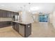 Modern kitchen with dark cabinets, island, and stainless steel appliances at 17841 Althea Blue Pl, Lutz, FL 33558