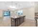 Modern kitchen with island, dark cabinetry, and stainless steel appliances at 17841 Althea Blue Pl, Lutz, FL 33558