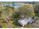 Aerial view of a single-story home next to a picturesque lake, with expansive green fields in the background at 1802 Mcgee Rd, Plant City, FL 33565