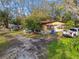 Exterior view of house with a ladder, landscaping, and assorted parked vehicles at 1802 Mcgee Rd, Plant City, FL 33565