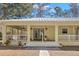 Front view of a yellow house with a large porch at 19256 Hidden Oaks Dr, Brooksville, FL 34604