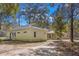 Yellow guest house with metal roof and green doors at 19256 Hidden Oaks Dr, Brooksville, FL 34604