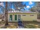 Guest house with metal roof, green doors, and ramp at 19256 Hidden Oaks Dr, Brooksville, FL 34604