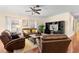 Bright living room featuring hardwood floors, leather furniture, and a ceiling fan at 19256 Hidden Oaks Dr, Brooksville, FL 34604