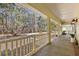 Covered porch with white railings and wooded view at 19256 Hidden Oaks Dr, Brooksville, FL 34604