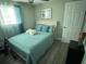 Cozy bedroom with teal bedding and window curtains at 2152 Arcadia Rd, Holiday, FL 34690