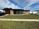 Ranch-style home with a well-maintained lawn and a screened porch at 2152 Arcadia Rd, Holiday, FL 34690
