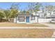 Newly renovated home with modern exterior and curb appeal; blue front door, white fence at 2302 E 23Rd Ave, Tampa, FL 33605