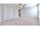 Spacious bedroom with ceiling fan, neutral carpet, and double doors to closet at 3059 Nubbin Ridge Ln, Zephyrhills, FL 33540