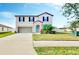Charming two-story home featuring a well-manicured lawn, attached garage, and covered front porch at 3059 Nubbin Ridge Ln, Zephyrhills, FL 33540