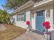 White single story home with blue door, landscaping, and a paved walkway at 3211 W Oakellar Ave, Tampa, FL 33611