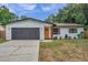 Updated home exterior with modern gray garage door and orange front door at 3445 10Th N Ave, St Petersburg, FL 33713