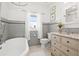 Updated bathroom with gray tile, vintage vanity, and a bathtub at 425 20Th Ne Ave, St Petersburg, FL 33704