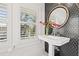 Modern bathroom with pedestal sink and dark hexagonal tile at 425 20Th Ne Ave, St Petersburg, FL 33704