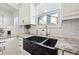 Farmhouse sink, granite countertop, and white cabinetry at 425 20Th Ne Ave, St Petersburg, FL 33704