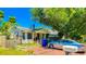 Cute yellow house with brick driveway, and a large tree in front at 616 2Nd Nw Ave, Largo, FL 33770