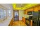 Open kitchen with wood cabinets, black appliances, and views to sunroom at 616 2Nd Nw Ave, Largo, FL 33770