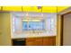 Bright kitchen features wood cabinets, black appliances, and a large window at 616 2Nd Nw Ave, Largo, FL 33770