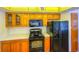 Kitchen boasts wood cabinets, black appliances, and ample counter space at 616 2Nd Nw Ave, Largo, FL 33770