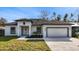 Newly built home with white exterior, dark gray accents, and a two-car garage at 6605 24Th S Ave, Tampa, FL 33619