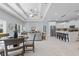 Open-concept living room and kitchen with marble floors, tray ceiling, stainless appliances, and a breakfast bar at 6605 24Th S Ave, Tampa, FL 33619