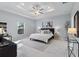 Well-lit main bedroom with tray ceiling, ceiling fan, marble floors, and a serene color scheme at 6605 24Th S Ave, Tampa, FL 33619