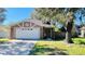 Cute one-story house with a white garage door and a spacious front yard at 7117 50Th E Ave, Palmetto, FL 34221